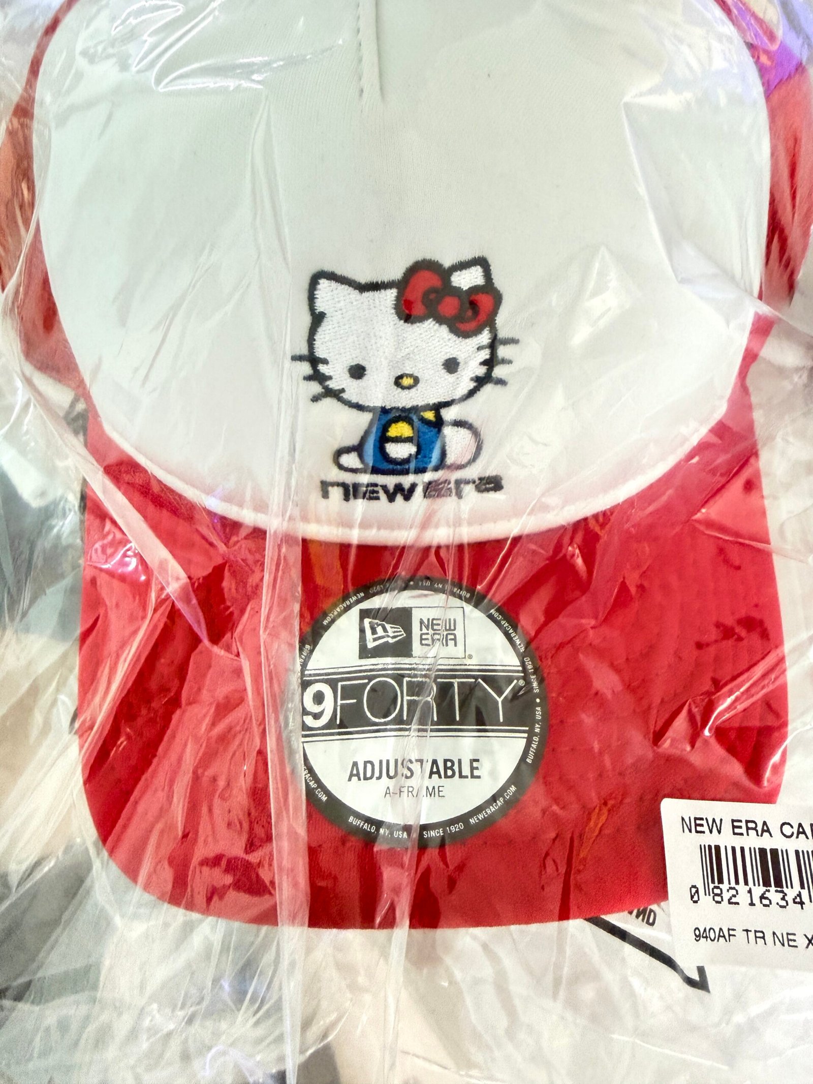 Red and white New Era Hello Kitty cap in packaging with a 9FORTY Adjustable A-Frame sticker
