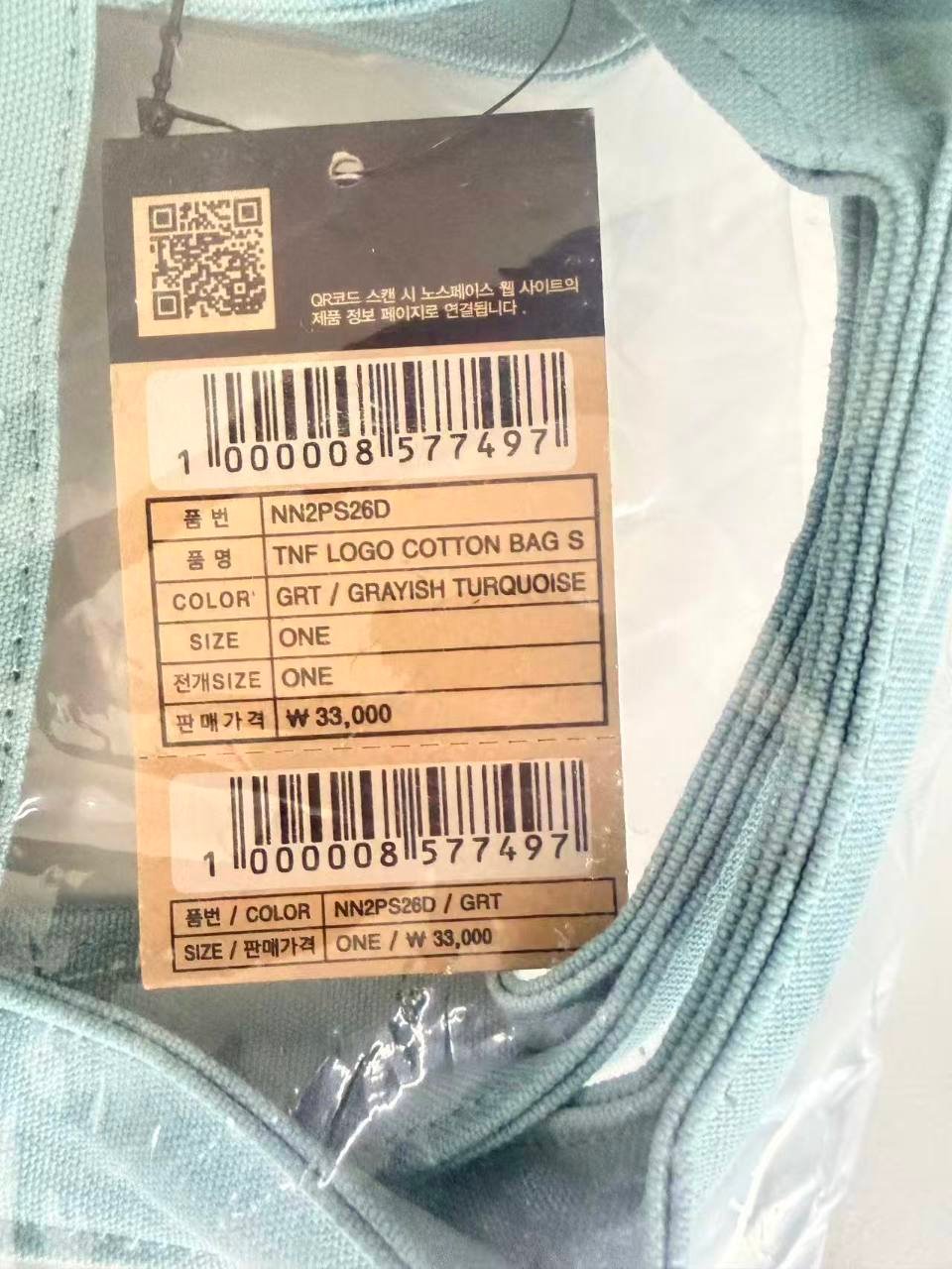 Close-up of The North Face Korea NN2PS26D hangtag showing color GRT size ONE and 33000 won