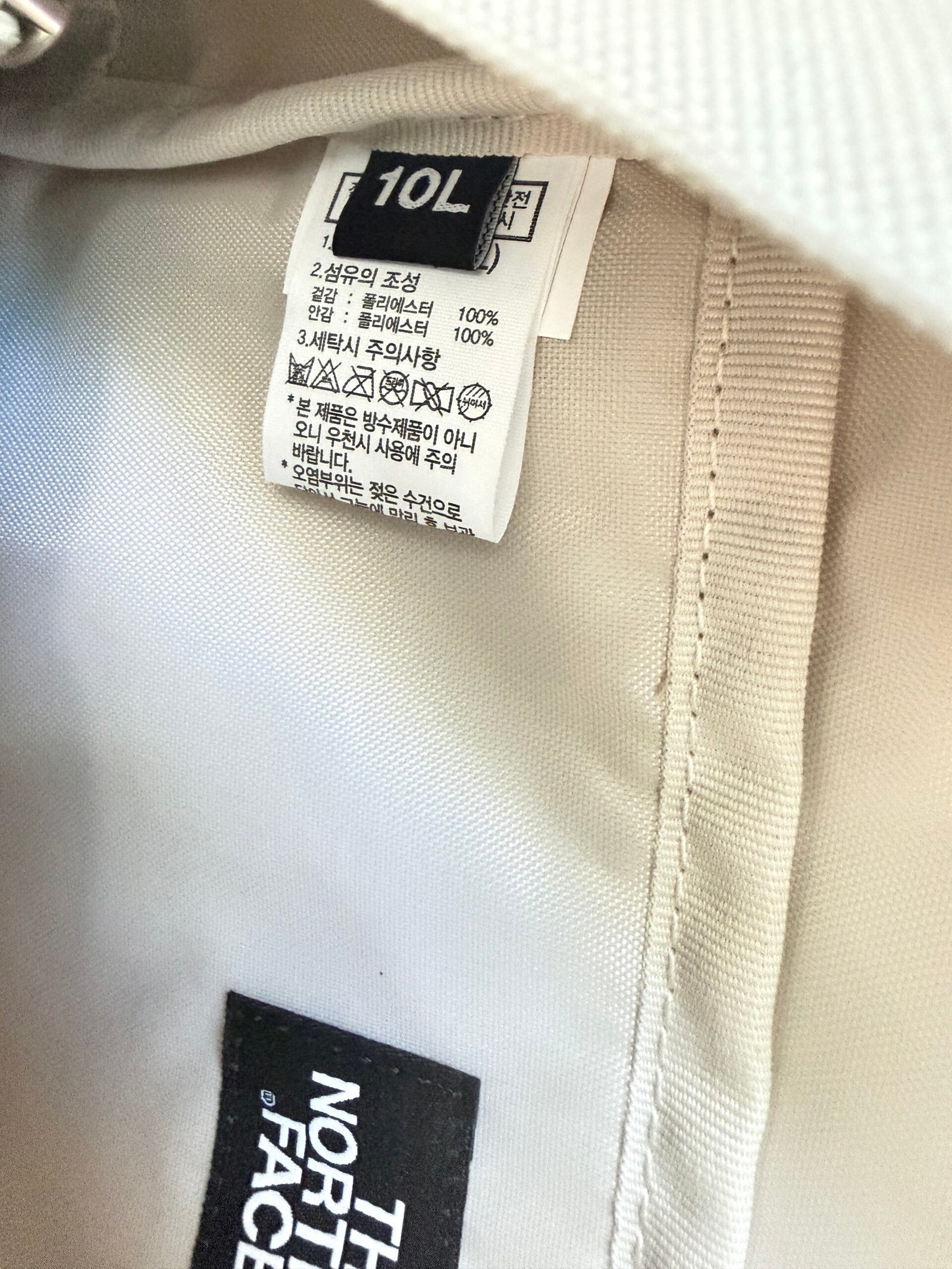 Inside backpack label showing 10L, polyester composition and a Korean warning that the bag is not waterproof
