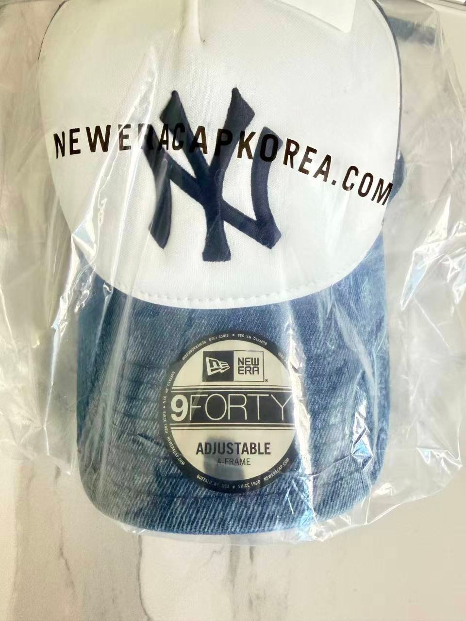 White-front NY cap with a blue brim: paired with MI 15206362 by the photo contributor.