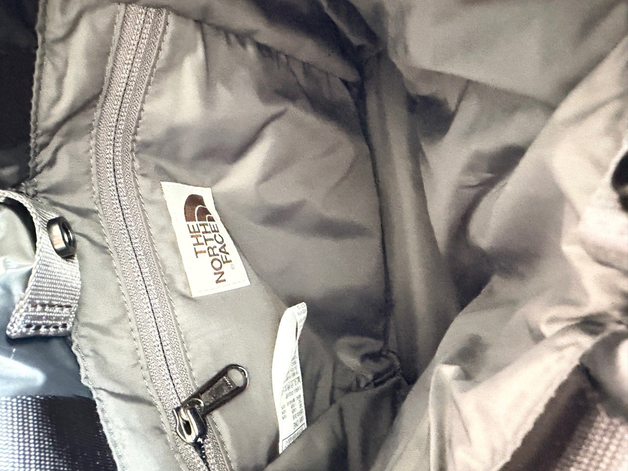 Interior of Bonney mini bucket bag showing a zipped pocket beside the sewn brand label